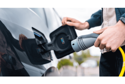 Pessoa conectando carro elétrico ao carregador