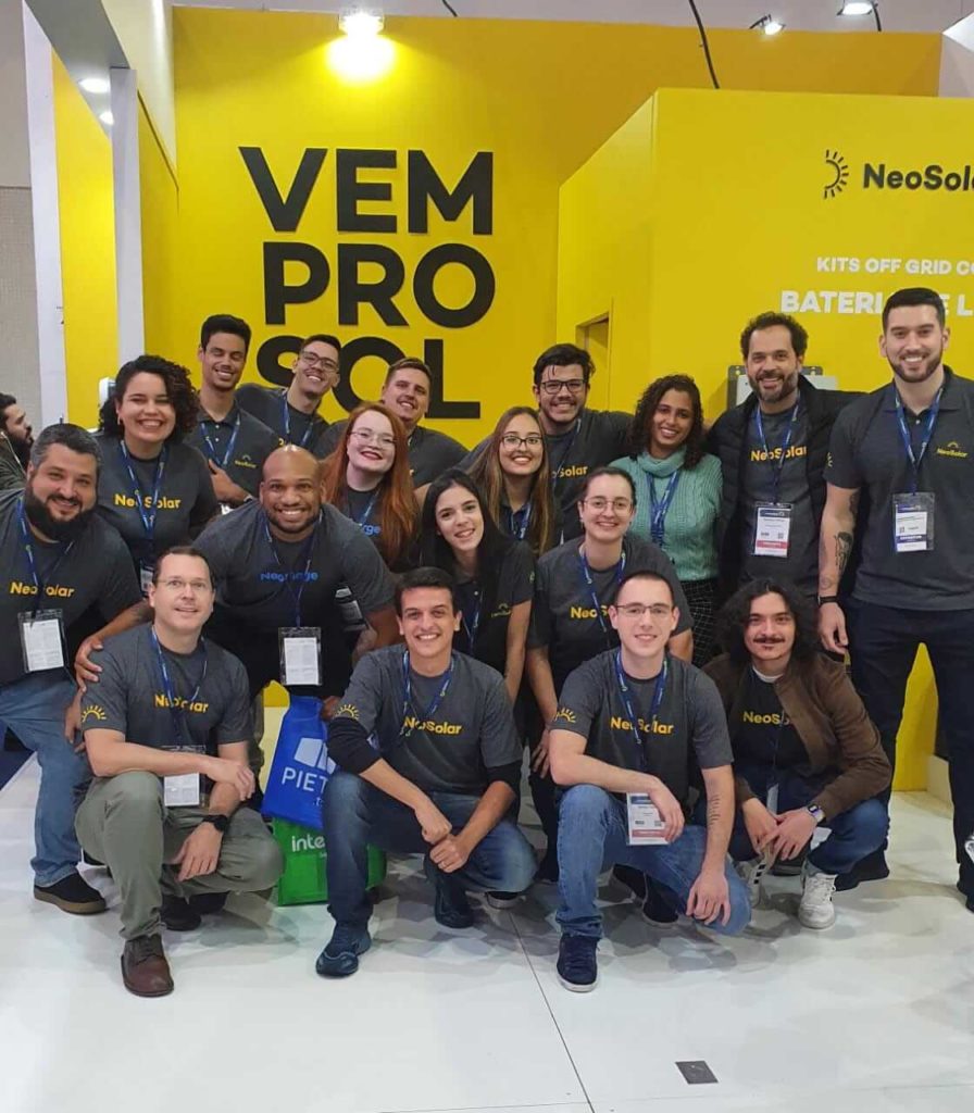 Equipe Neosolar reunida em frente ao estande do Intersolar 2022.