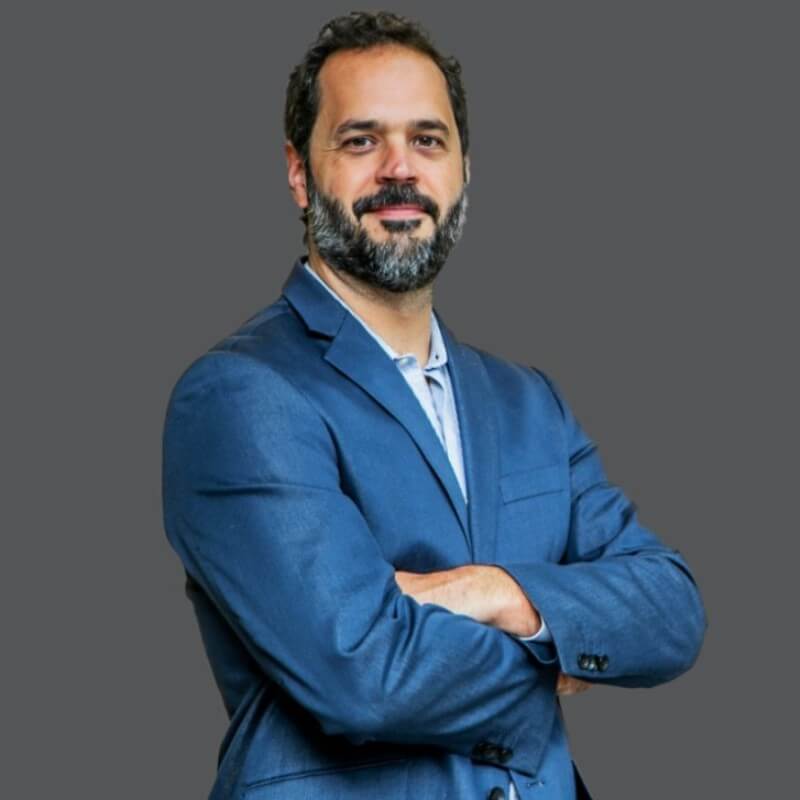 Rapael Pintão (sócio fundador da NeoSolar) de braços cruzados posando para uma foto.