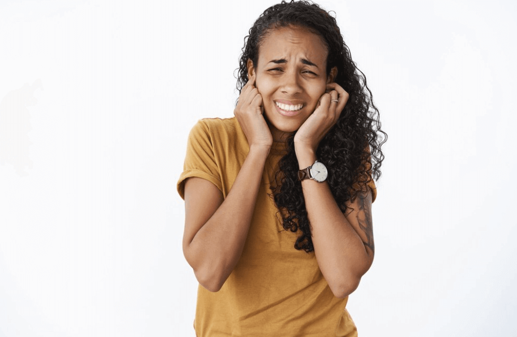 Mulher tapando os ouvidos com as mãos